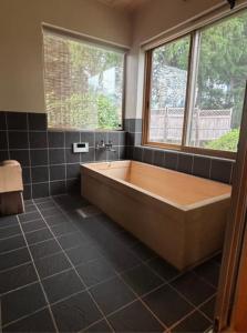 Matsukawaにある離れの宿 かぶろの庭の窓のある浴室に大きな浴槽がある