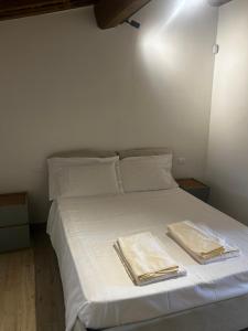 een wit bed met twee handdoeken erop bij Casa Rachele in Arezzo