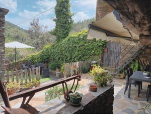 un jardín con mesa, sillas y plantas en A Casa da Natália, en Alvares