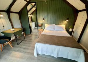 a bedroom with a bed and a table in a room at Éden Bed & Nature in Praia Grande