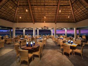 ein Restaurant am Strand mit Tischen und Stühlen in der Unterkunft El cid La ceiba beach in Cozumel