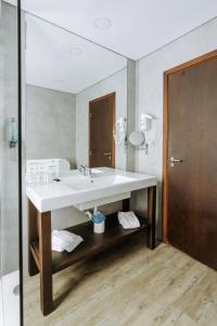 a bathroom with a white sink and a mirror at Hotel Euro Moniz in Porto Moniz