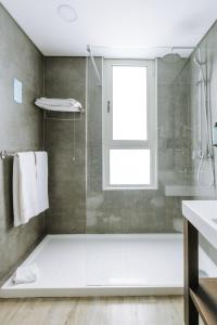 a bathroom with a shower and a glass shower stall at Hotel Euro Moniz in Porto Moniz