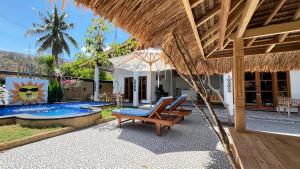 a villa with a swimming pool and a straw umbrella at Sun Resort And Villa Gili Trawangan in Gili Trawangan