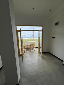 uma sala com mesa e cadeiras e uma varanda em The Sunset Weligama em Weligama