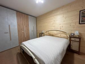 a bedroom with a bed and a wooden wall at Al Mulino in Schilpario