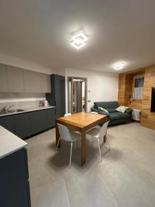 a kitchen and living room with a table and a couch at Al Mulino in Schilpario +3 photos