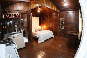 a bedroom with a bed in a room with wooden walls at Chalé Primavera in Juquitiba +80 photos