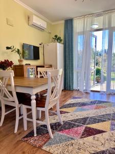 a dining room with a table and chairs and a refrigerator at Krupitskiy House in Chakvi