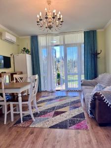 a dining room with a table and chairs and a room with a couch at Krupitskiy House in Chakvi +32 photos