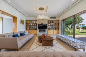a living room with a couch and a table at Sublime villa, piscine chauffée, petit déjeuner inclus in Sehib Foukani