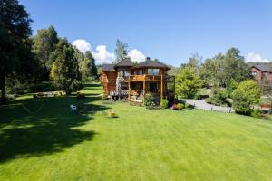 a large yard with a wooden house in the yard at ROTUI CABAÑA EXCLUSIVA DON FERMIN in San Martín de los Andes