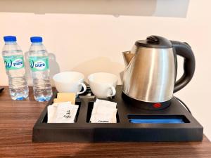 a tea kettle and two bottles of water on a table at Shing Spa Resort in Brooke's Point