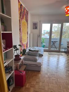 ein Wohnzimmer mit einem Bett und einem Balkon in der Unterkunft Forêt Lausanne in Lausanne