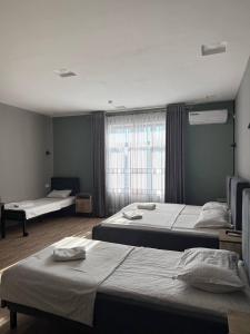 a bedroom with two beds and a window at Nari 2 Hotel in Toshkent-Passajir Bekati +24 photos