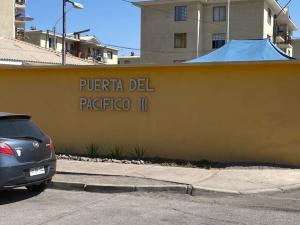 a yellow wall with the words puerto del patricio at D14-9 Arriendo diario a pasos de la playa Arica in Arica