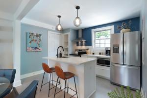 a kitchen with blue walls and an island with bar stools at Harmony House in Nashville