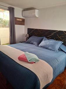 a bedroom with a blue bed with blue and red pillows at Habitaciones Barrancas en San Antonio - Cabañas y Mini Departamentos in San Antonio