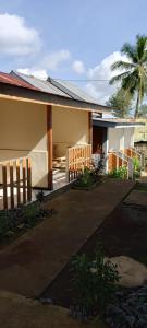 a house with a fence and a palm tree at Pin senaru accomodation in Senaru +13 photos