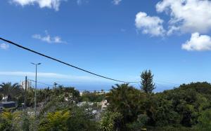 a view of a city with trees and a blue sky at Coin de paradis in Le Tampon