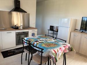 a small kitchen with a table and a refrigerator at Coin de paradis in Le Tampon