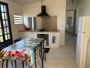 a kitchen with a table and a refrigerator at Coin de paradis in Le Tampon