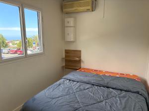 a small bedroom with a bed and a window at Coin de paradis in Le Tampon
