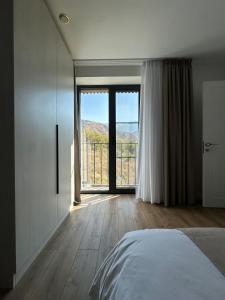 ein Schlafzimmer mit einem Bett und einem großen Fenster in der Unterkunft RODNIK guesthouse in Besqaynar + 26 Fotos