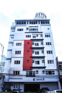 a tall white building with red at The Studio 18 Residences in Manila