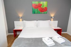 1 dormitorio con 1 cama blanca y 2 mesas rojas en Hotel Liqeni, en Tirana