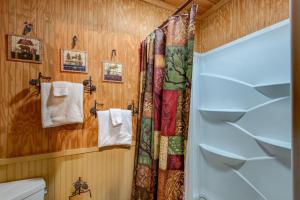 a bathroom with a shower and a toilet and towels at Bridgepoint Cabin in Banner Elk +38 photos