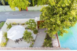 an overhead view of a table and chairs next to a tree at Oceanvine Maldives in Mahibadhoo