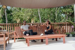 a man and a woman sitting on a bench at Mapache Hostel in Holbox Island +50 photos