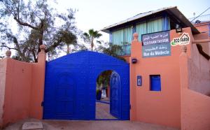 una puerta azul frente a un edificio en Eco Farm Tayssir Marrakech, en Marrakech