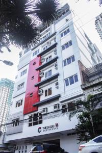 ein hohes weißes Gebäude mit roter Farbe darauf in der Unterkunft The Studio 18 Residences in Manila