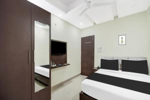een slaapkamer met een bed en een tv erin bij Super Hotel O CITY HEIGHTS in Dhanbad +22 foto's