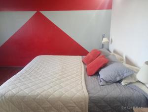 ARoss في أوشوايا: غرفة نوم بسرير ابيض بجدار احمر