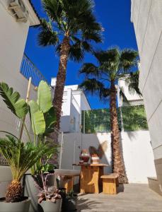 two palm trees in a courtyard with a table at Casa de la Suerte in San Fulgencio
