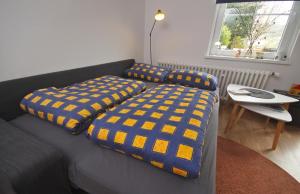 a living room with a couch with yellow and blue cushions at ÜbermTal in Schmallenberg