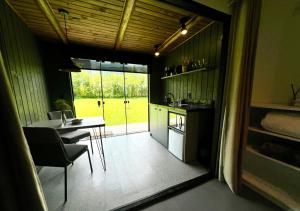 a kitchen and dining room with a table and a window at Éden Bed & Nature in Praia Grande