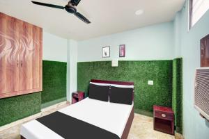 een slaapkamer met een groene muur en een bed bij Super Hotel O CITY HEIGHTS in Dhanbad