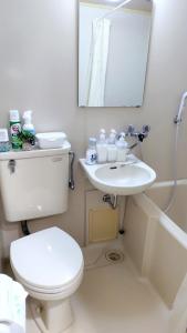 een badkamer met een toilet, een wastafel en een spiegel bij Kokusaigakusya Ozukikaikan - Vacation STAY 18798 in Hadano