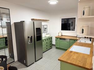 a kitchen with green cabinets and a stainless steel refrigerator at Romantic getaway with pool & panoramic vineyards in Eltville