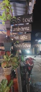 a sign for a cafe with plants and a bike at Ning Ning hostel Dondet in Don Det +1 photo