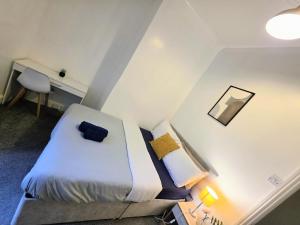 ein Schlafzimmer mit einem Bett und einem Schreibtisch mit Lampe in der Unterkunft Union Palace, Free Parking in Blythe