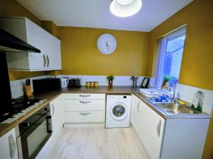 eine Küche mit einer Waschmaschine und einer Uhr an der Wand in der Unterkunft Union Palace, Free Parking in Blythe + 37 Fotos