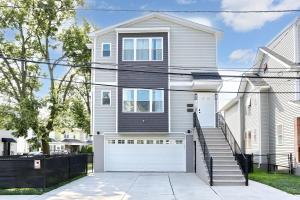 a white house with a white garage door at Newly Built Lake House Near NYC EWR MetLife AD Mall in Passaic