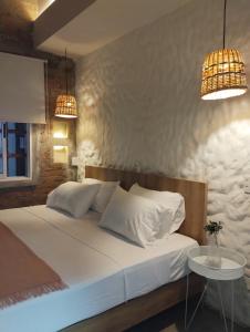 1 dormitorio con 1 cama blanca con 2 lámparas y mesa en La Casa de Nelly - Medellín, en Medellín