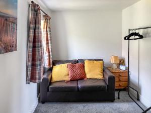 ein Wohnzimmer mit einer braunen Couch in einem Zimmer in der Unterkunft Moglett Cottage in Fincham