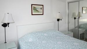 Cape May PointにあるSomewhere In Time Unit 4のベッドルーム1室(ベッド1台、ランプ2つ、鏡付)